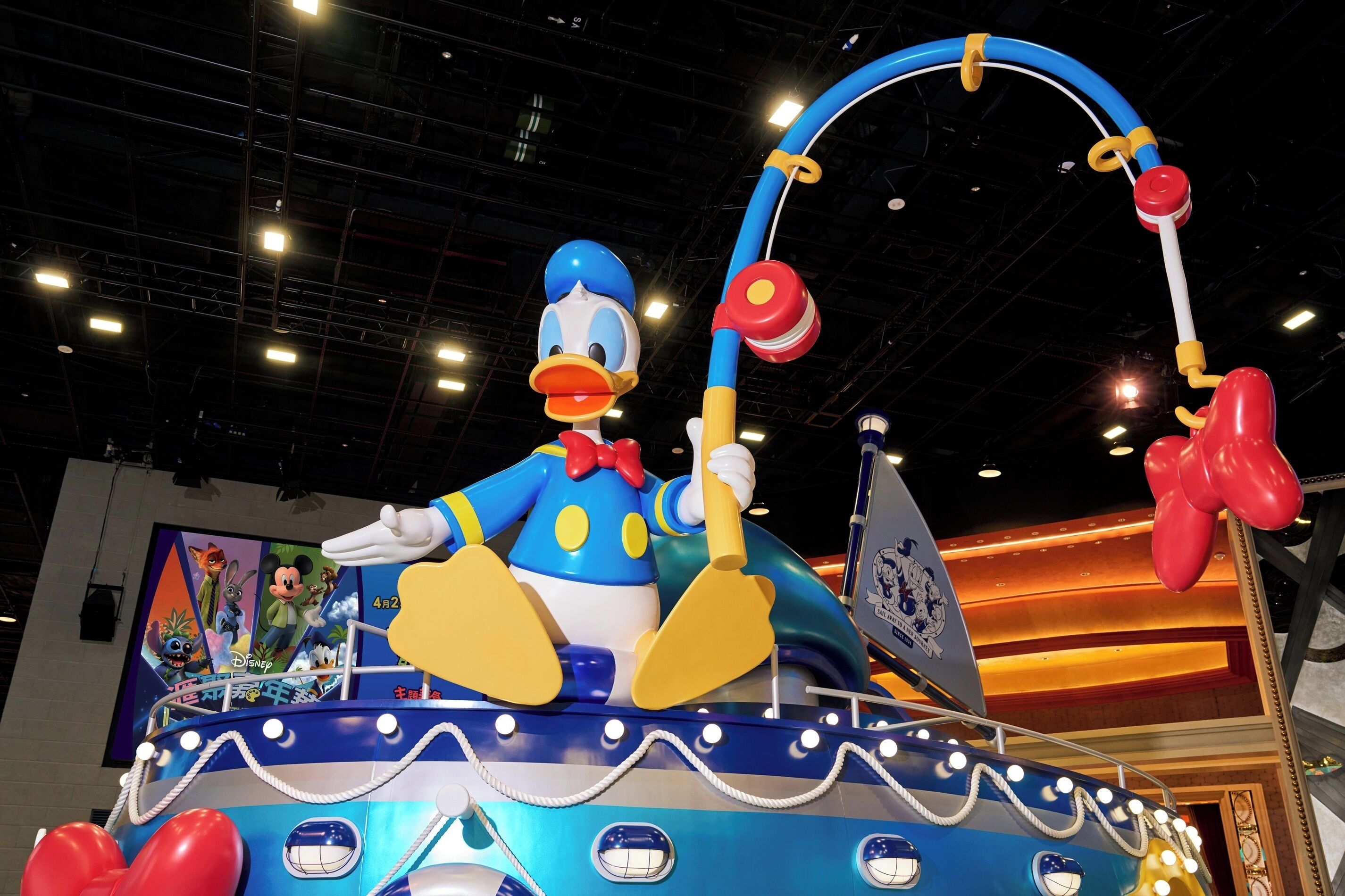 A large, colorful ride with a character figure, surrounded by lights and a backdrop with characters.