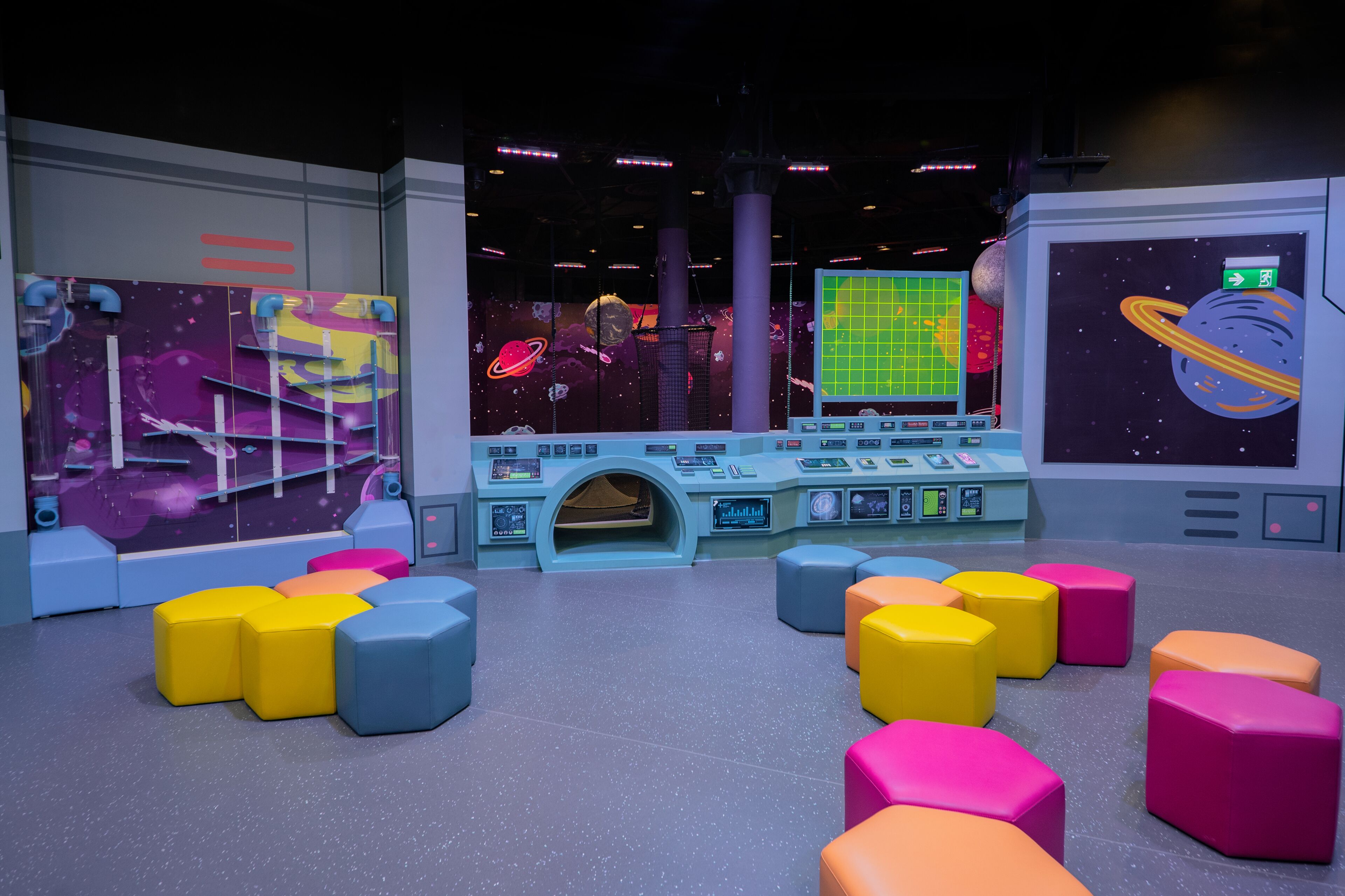 A space-themed play area with colorful seating and control panels.