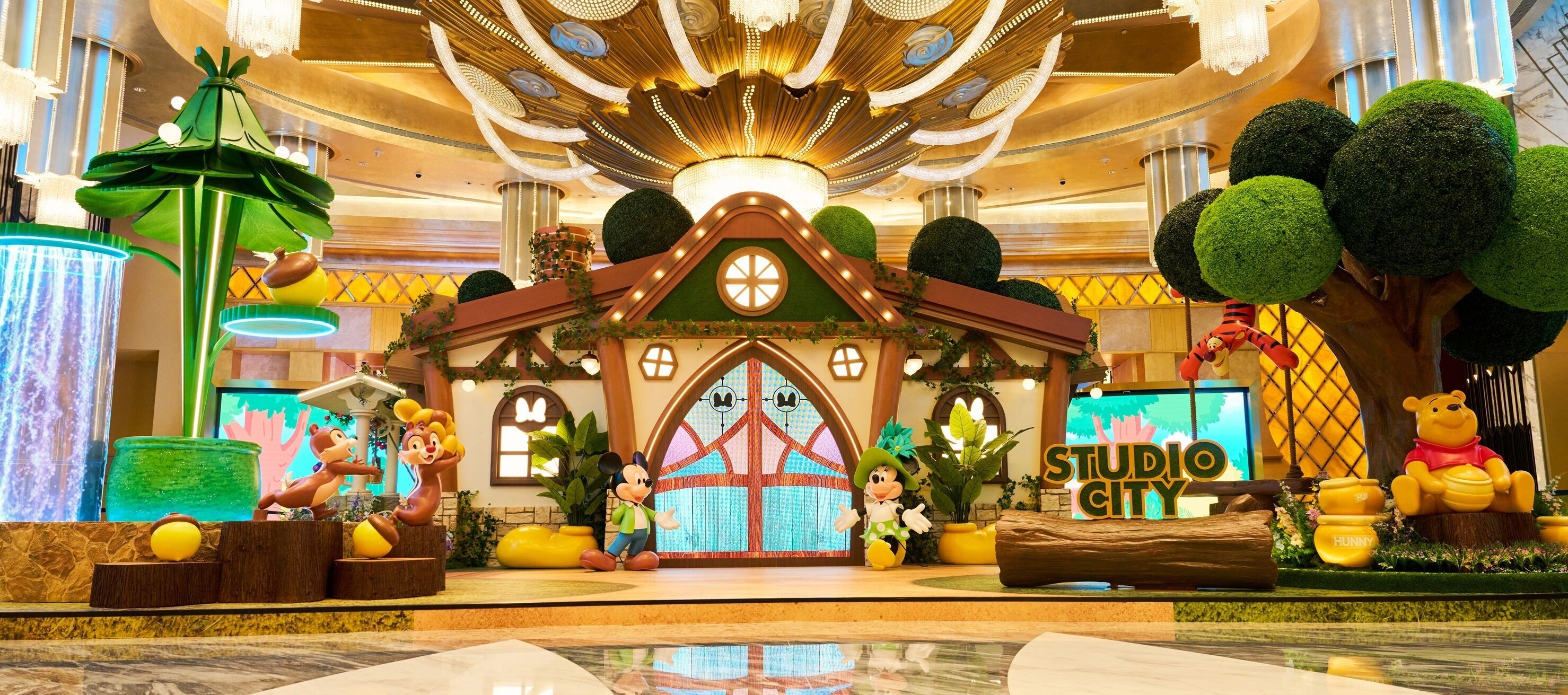 Un vestíbulo temático con un escenario central, árboles decorativos y un cartel que dice 'STUDIO CITY'.