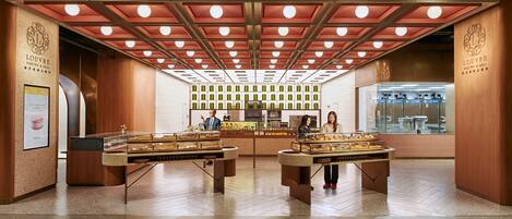 A bakery with a modern design, featuring a central display counter and a refrigerated display case.
