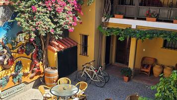 Un patio con mobiliario exterior, una bicicleta y un mural.