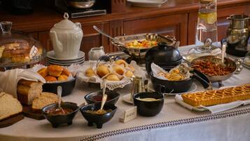 Uma mesa de buffet com diversos alimentos e utensílios de servir.