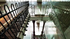 An indoor staircase with metal railings and glass panels, leading to a higher floor. - Elite Hotel Mimer (Umea)