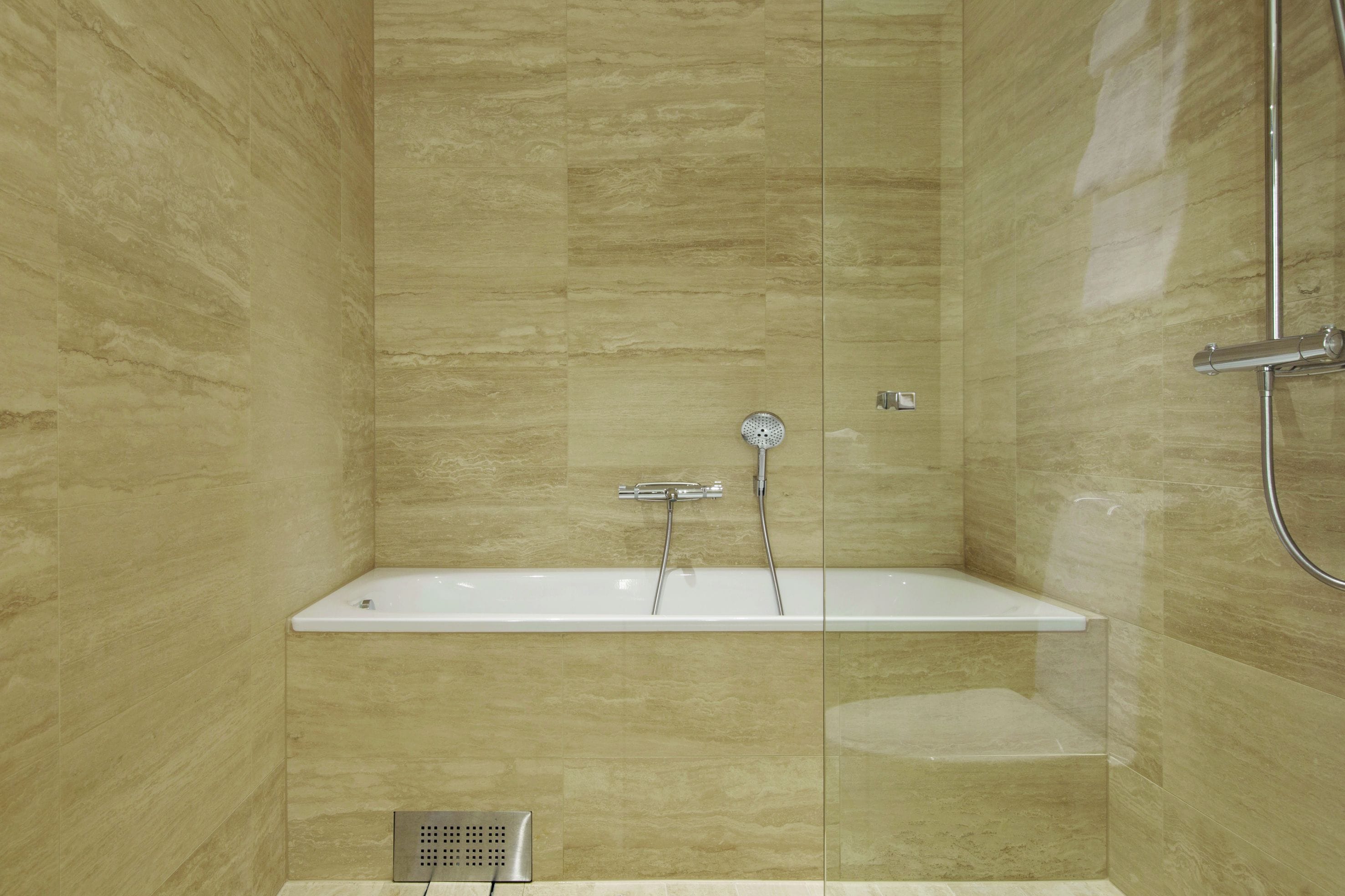 A modern bathroom with a freestanding bathtub, a showerhead, and a wall-mounted faucet.