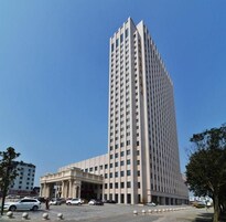 Un edificio alto y moderno con fachada simétrica y entrada central.