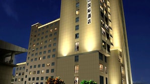 Un grand hôtel, un immeuble de grande hauteur avec de nombreux étages, des fenêtres illuminées et une enseigne bien visible.