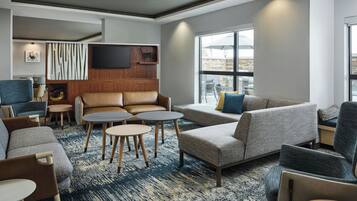 Un área de descanso moderna con sofás, sillones y una mesa de centro.