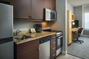 A compact kitchen with a microwave, coffee maker, and dishwasher.