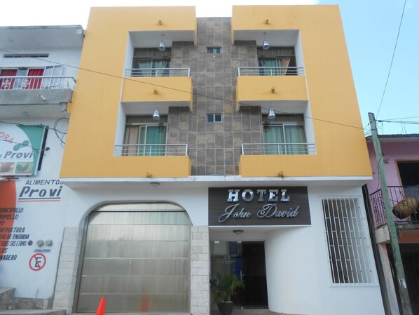 A hotel named "John David" with a yellow facade, multiple balconies, and a visible entrance.