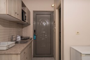 A compact kitchen with a microwave, a toaster, and a sink. - Karras Livin (Zakynthos)