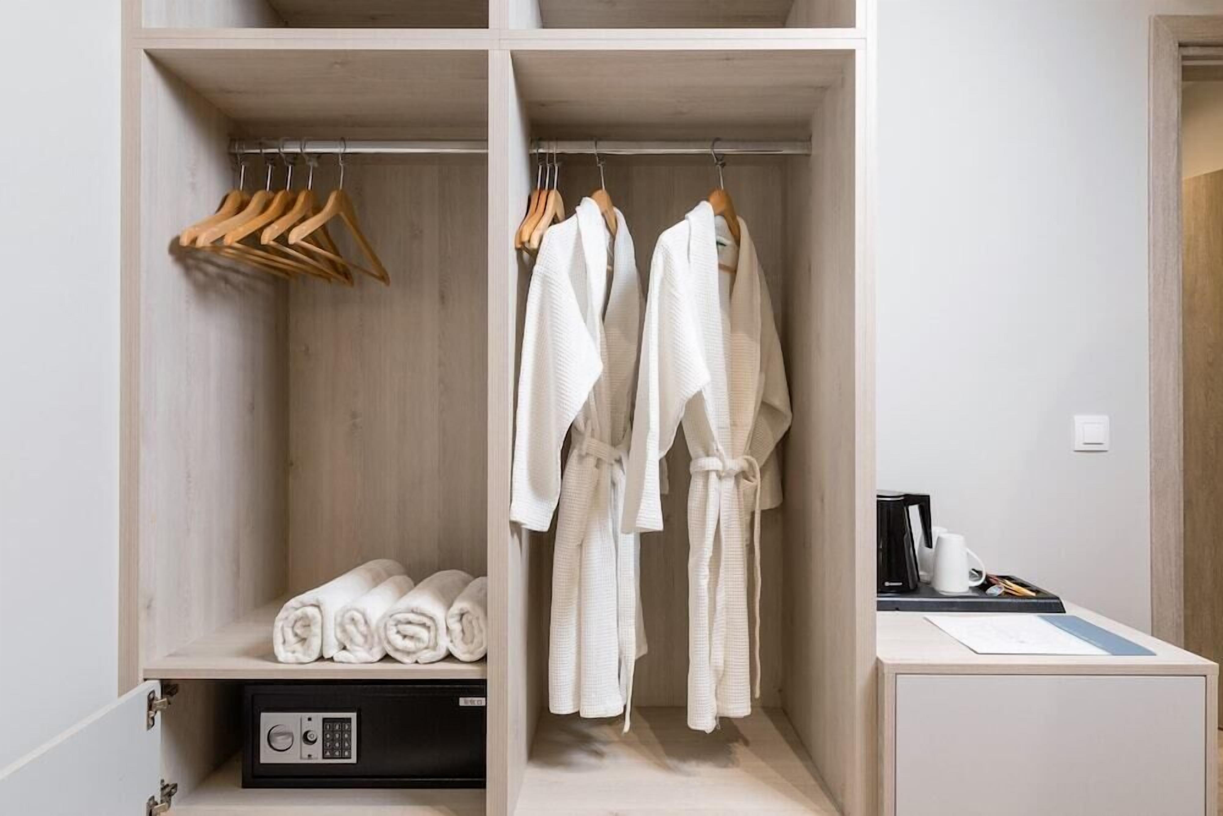 A walk-in closet with wooden shelves, a black appliance, and a small desk with a coffee maker.