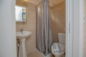 Un baño con ducha, inodoro y lavamanos.