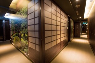 Een gang met een traditionele Japanse wandversiering met een natuurscène.