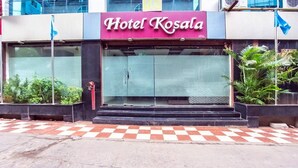 Hotel Kosala with a checkered pavement in front, a glass entrance, and potted plants on the right. - Hotel Kosala (Vijayawada)