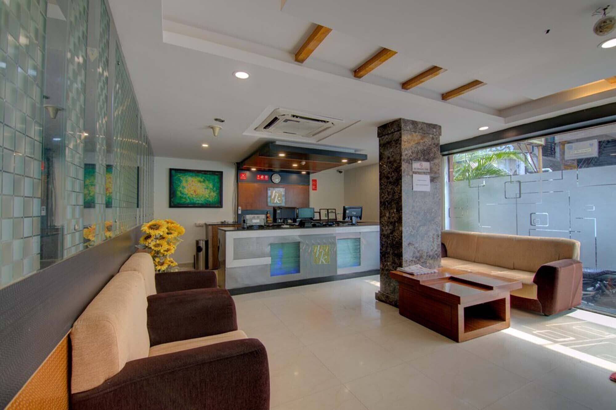A modern lobby with a reception desk, seating area, and a large window.
