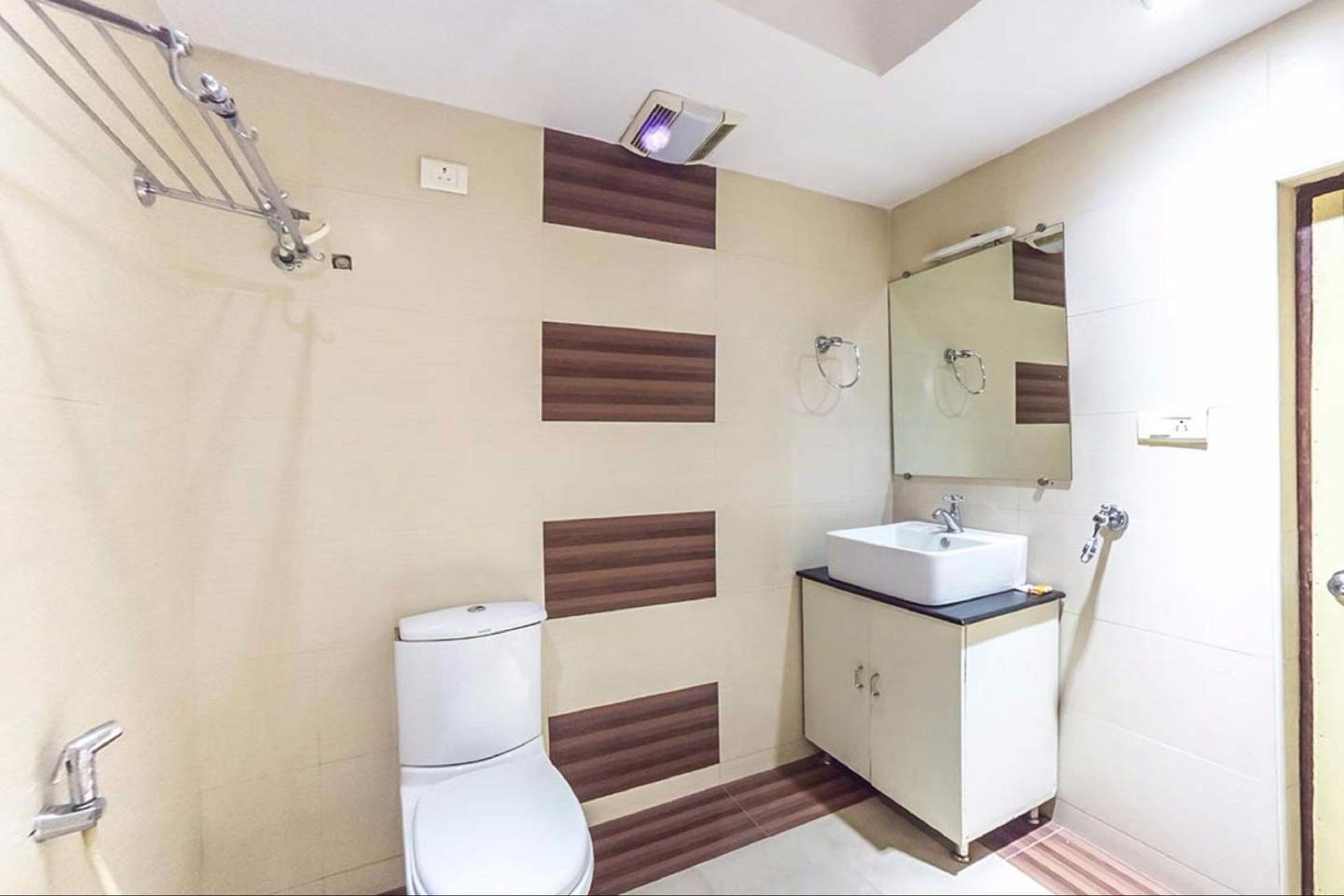 A bathroom with a toilet, sink, and shower area.