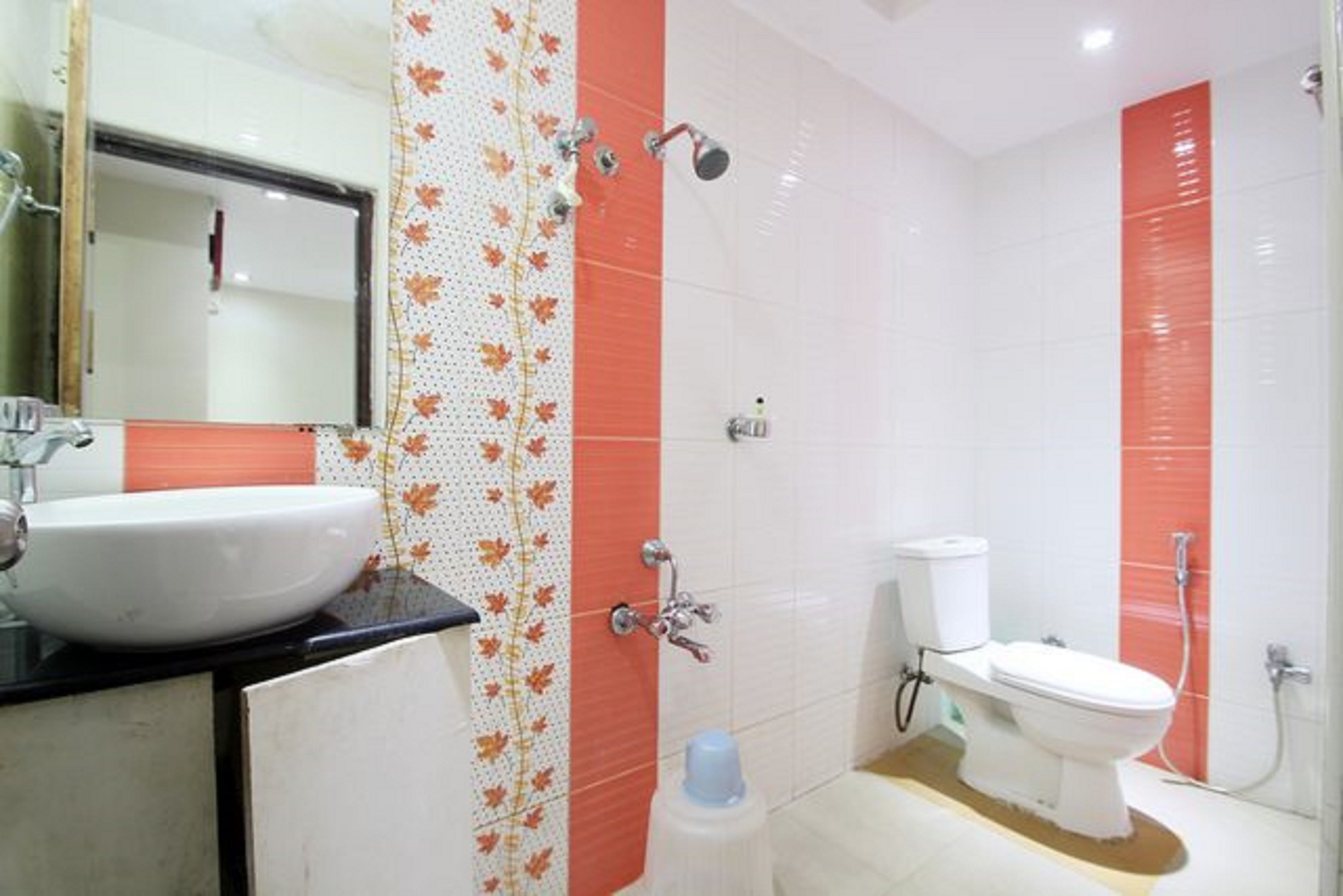 Un baño con lavamanos blanco, inodoro y ducha.