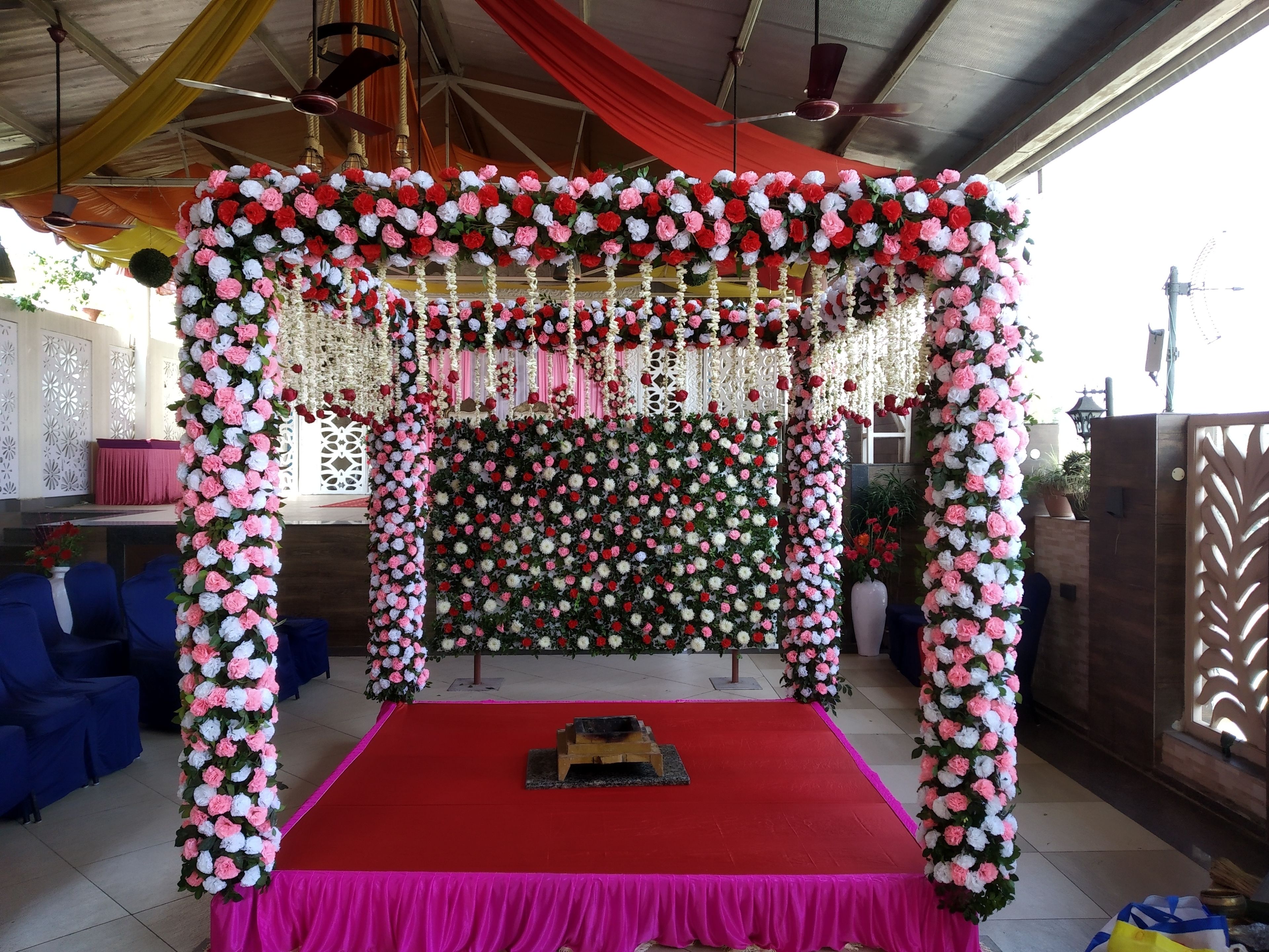 Une scène décorée, avec un tapis rouge et des arrangements floraux.