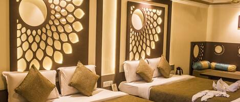 Habitación de hotel con dos camas, un amplio muro decorativo y un ventilador de techo.