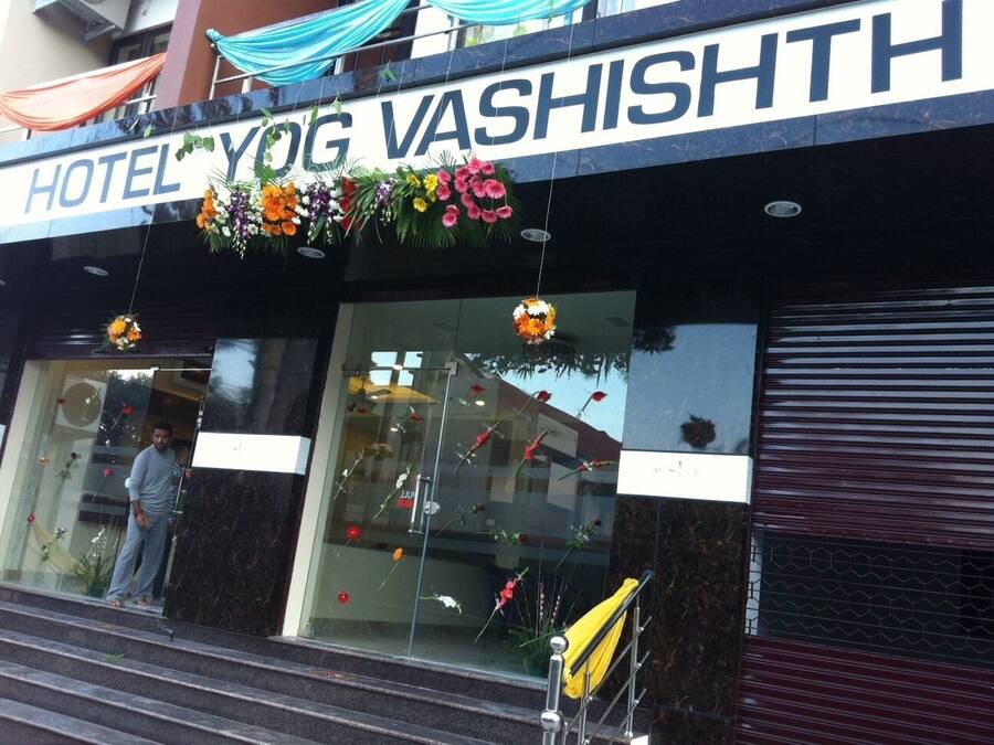 Ein Hotel Eingang mit einem Schild, auf dem 'HOTEL YOG VASHISHTH' steht.