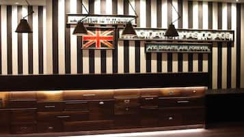 A reception desk with a striped wall, a British flag, and motivational signs.