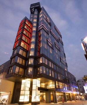 A modern building with multiple floors, large windows, and a prominent corner structure. - Hotel Indigo Kaohsiung Central Park by IHG (Kaohsiung)