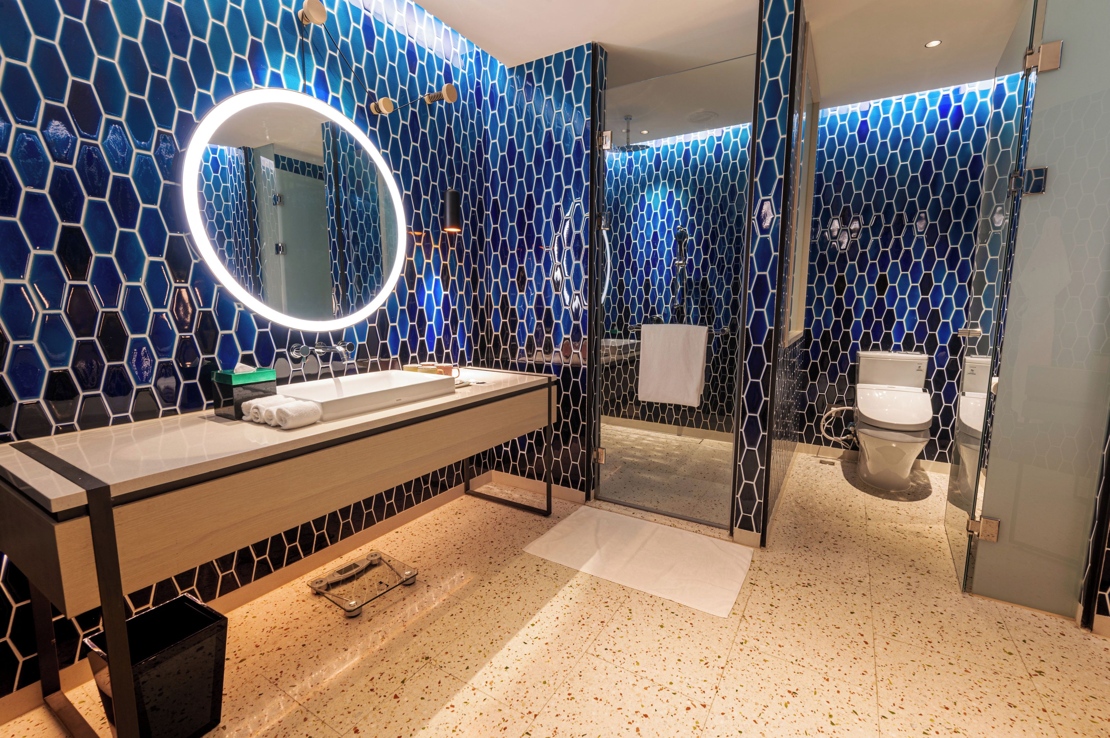 Une salle de bain moderne avec un grand miroir, un lavabo et des toilettes.