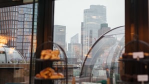 A view through a window with a cityscape in the background, including modern buildings and a bridge. - Montcalm Royal London House, Autograph Collection (London)