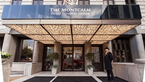 The entrance of The Montcalm Royal London House with a modern design, featuring a glass door and a geometric light fixture above. - Montcalm Royal London House, Autograph Collection (London)