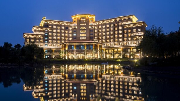 A large, multi-story hotel with a central courtyard and reflection in the water. - Yuluxe Hotel Taizhou (Taizhou)