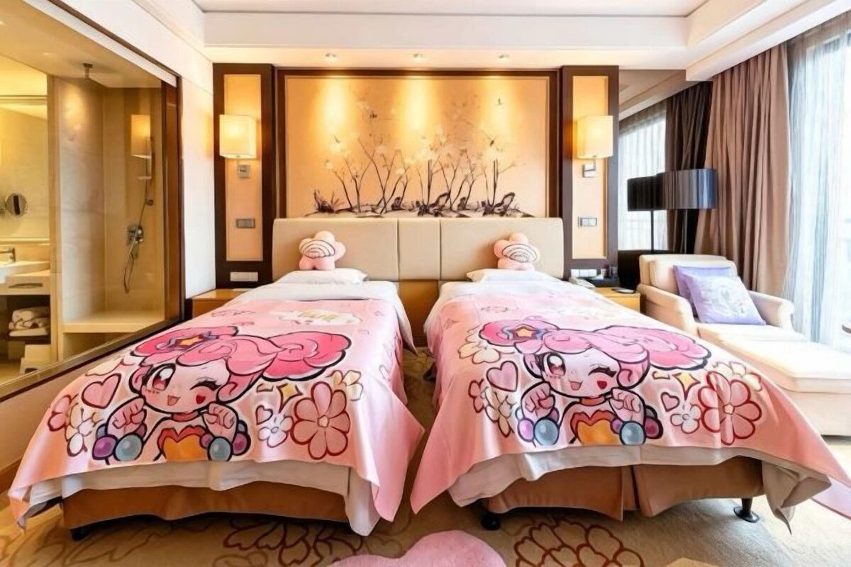 Una camera d'albergo con due letti, un divano, uno specchio grande e una decorazione a parete.
