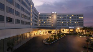 Un hôtel à plusieurs étages, reconnaissable à son grand panneau « Park Inn », doté d’un vaste parking et d’une entrée bien éclairée.