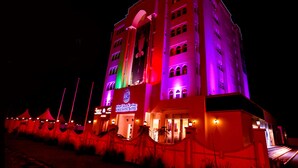 A hotel with multiple floors, a prominent entrance, and a sign indicating it is a hotel.
