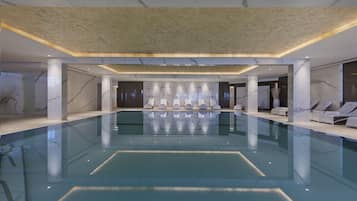 Een binnenzwembad, een buitenzwembad en parasols bij het zwembad