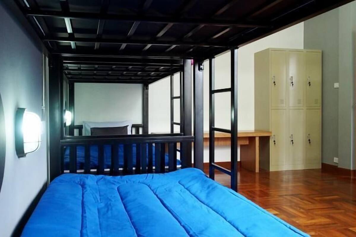 A room with a bunk bed, a wardrobe, and a desk.