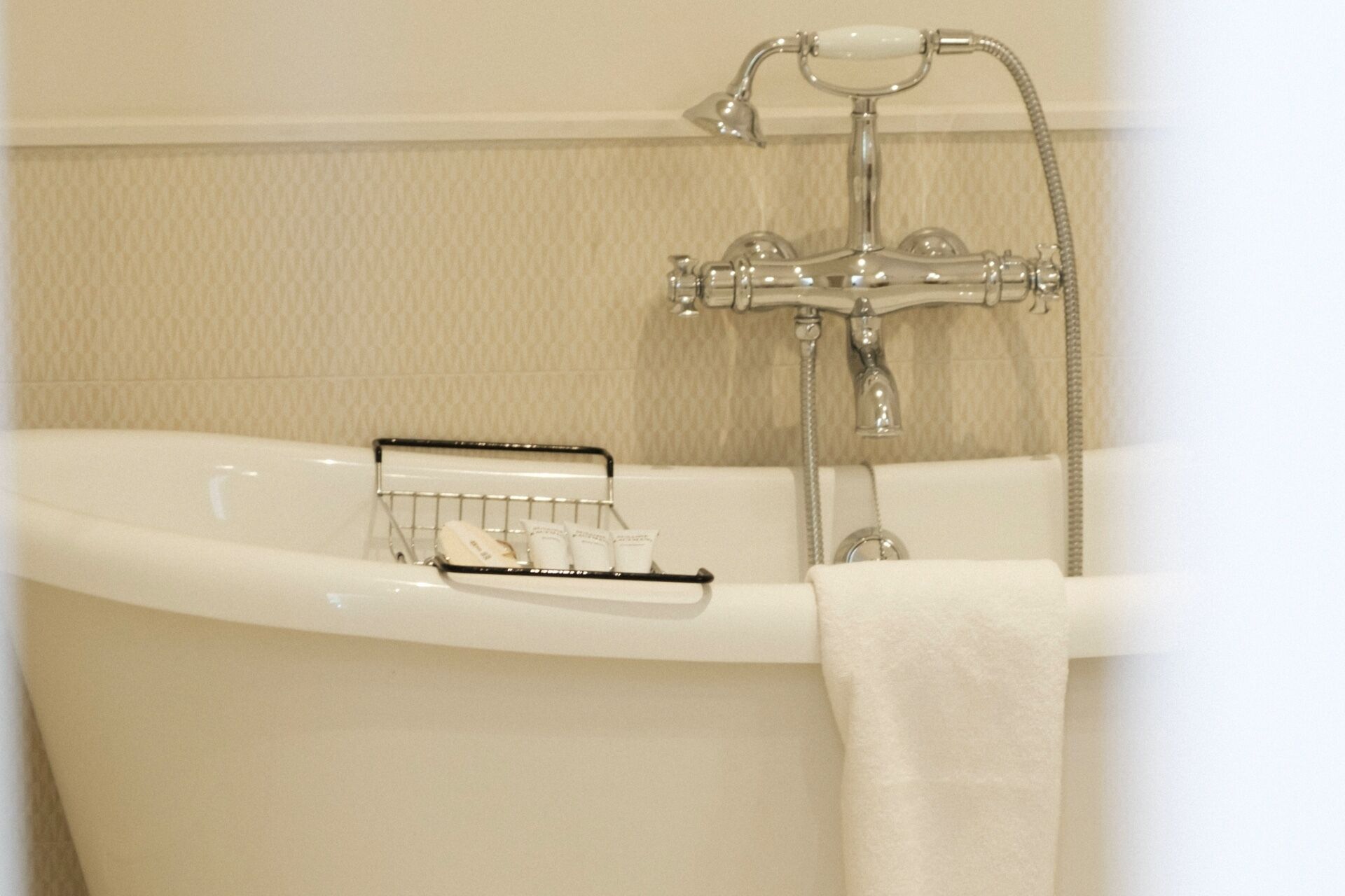Una bañera con toallero y ducha.
