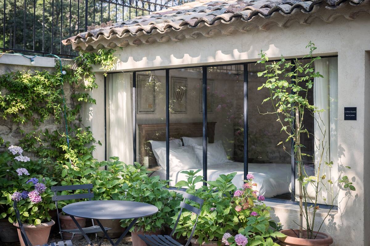 Une chambre à coucher avec un lit, une fenêtre et une vue sur le jardin.