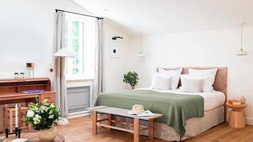 Un dormitorio con cama, mesita de noche, lámpara y escritorio con silla.