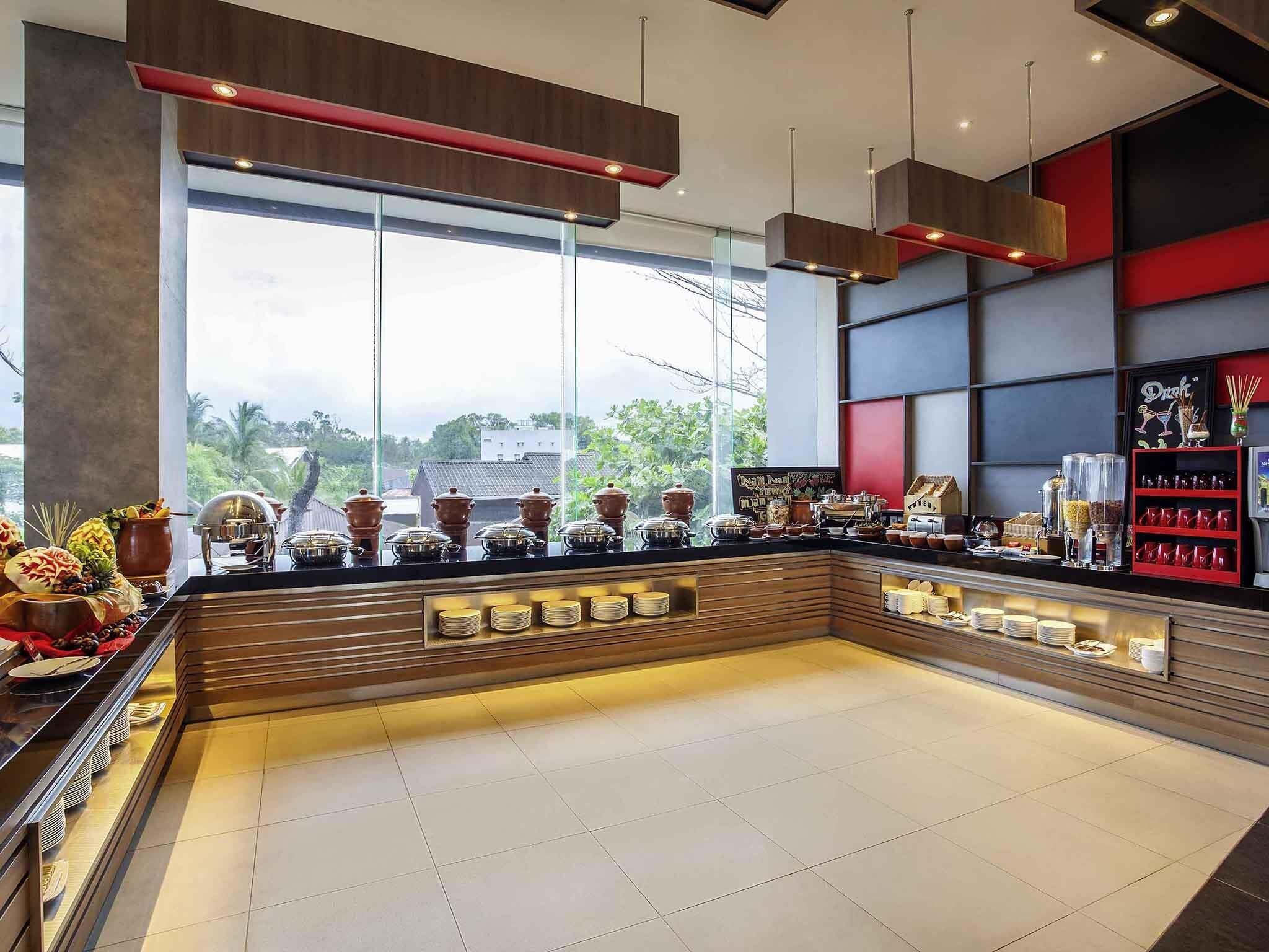 A modern breakfast bar with a view of greenery outside.