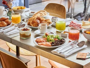 A breakfast buffet with various food items, drinks, and utensils on a table. - Boutet Bastille Hotel Paris - MGallery Collection (Paris)