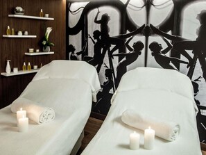A spa room with two beds, candles, and a wall with a silhouette mural. - Boutet Bastille Hotel Paris - MGallery Collection (Paris)