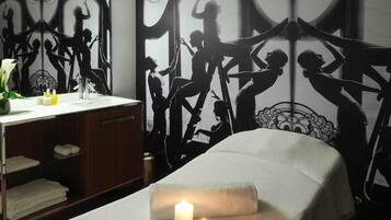 Une pièce comprenant un lit, un miroir et un mur orné d’une œuvre d’art représentant une silhouette.