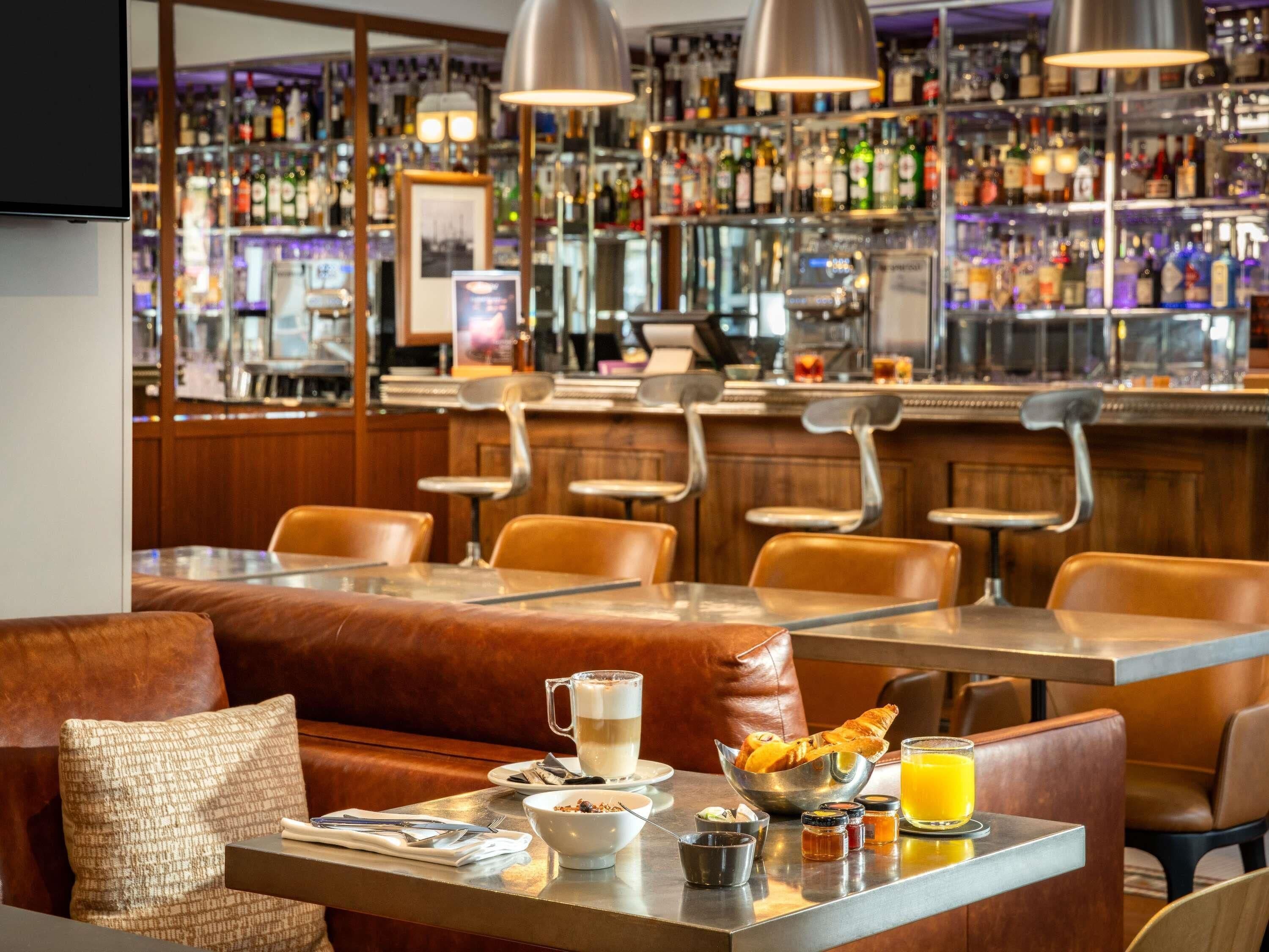 Un'area bar con diverse bottiglie di liquore, un bancone e posti a sedere.