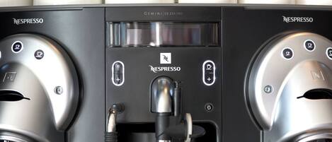 A Nespresso coffee machine with two dispensers and a control panel.