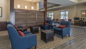A spacious lobby with blue sofas, a patterned wall, and a large window. - Comfort Suites Dunnellon near Rainbow Springs (Dunnellon)