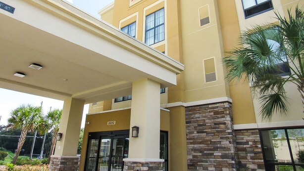 A hotel with a yellow facade, a sign reading "Comfort Suites," and a covered entrance area. - Comfort Suites Dunnellon near Rainbow Springs (Dunnellon)
