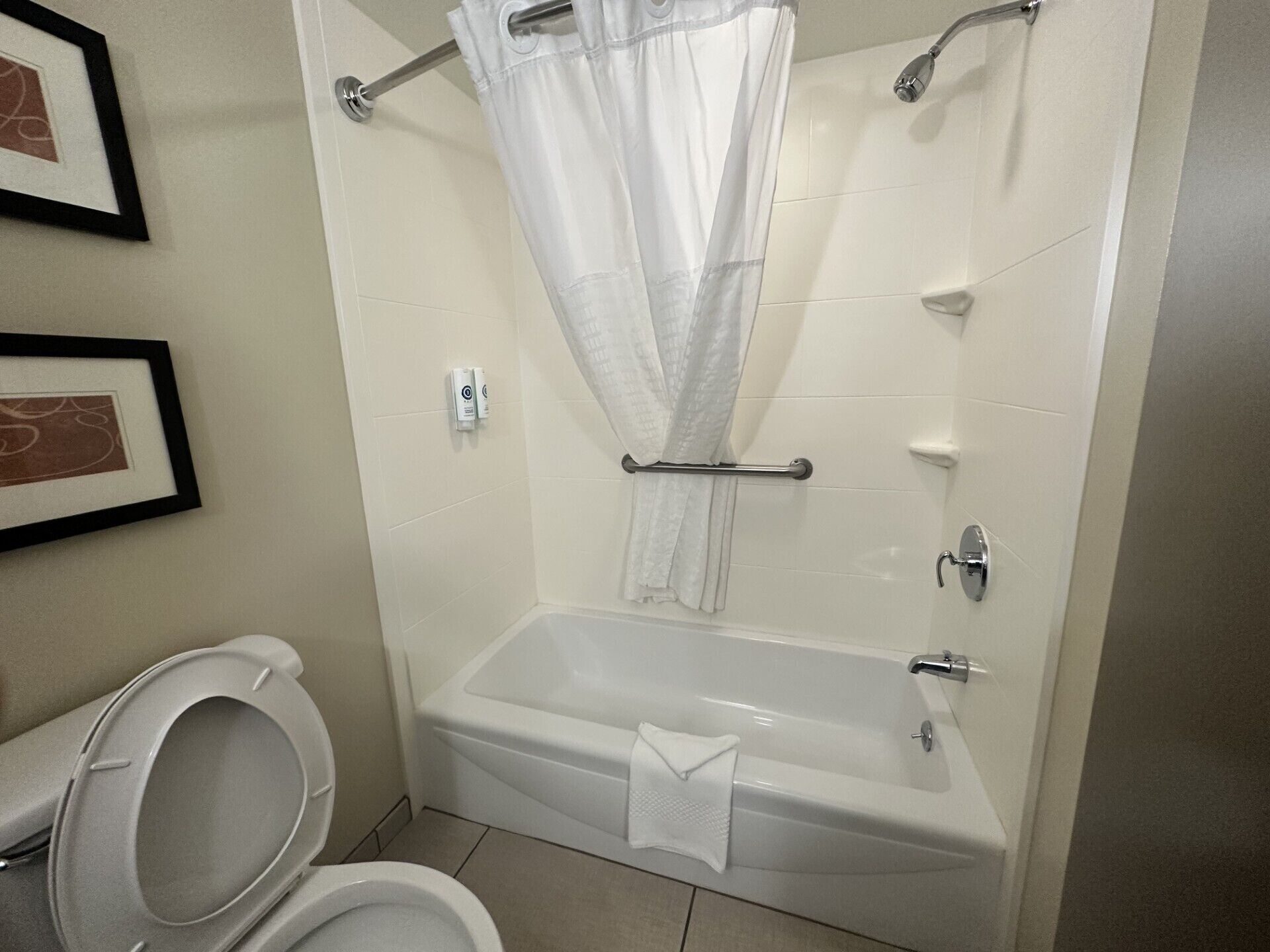 Een badkamer met een bad, toilet en douchegordijn.