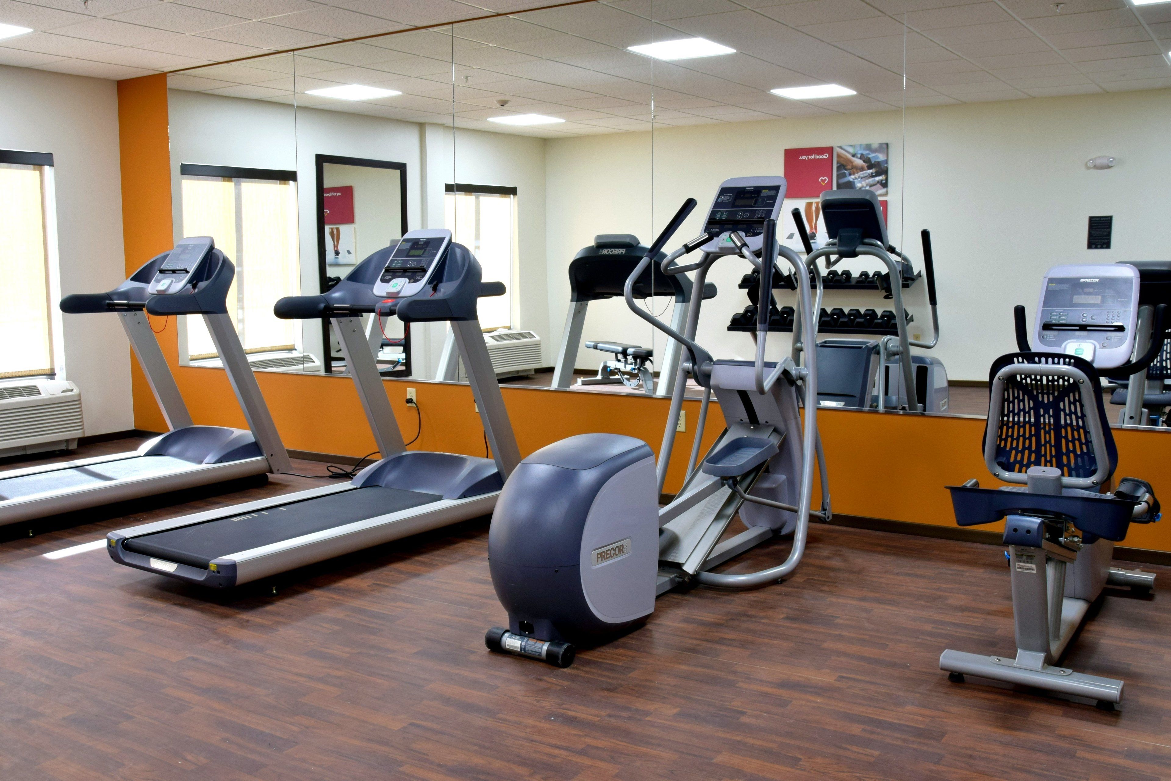Une salle de sport équipée de tapis de course, d’elliptiques et d’un vélo d’appartement.