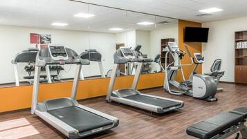 A gym with treadmills, an elliptical, and a bench.