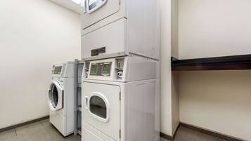 A laundry room with two stacked washing machines and a dryer.